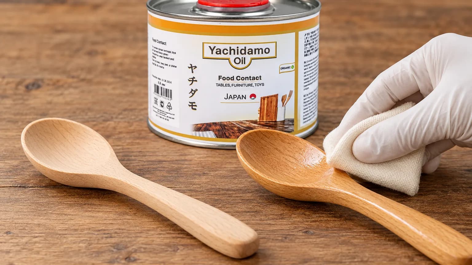 Банка Yachidamo Oil Food Contact стоит рядом с двумя буковыми ложками, одну из которых промасливают белой салфеткой.