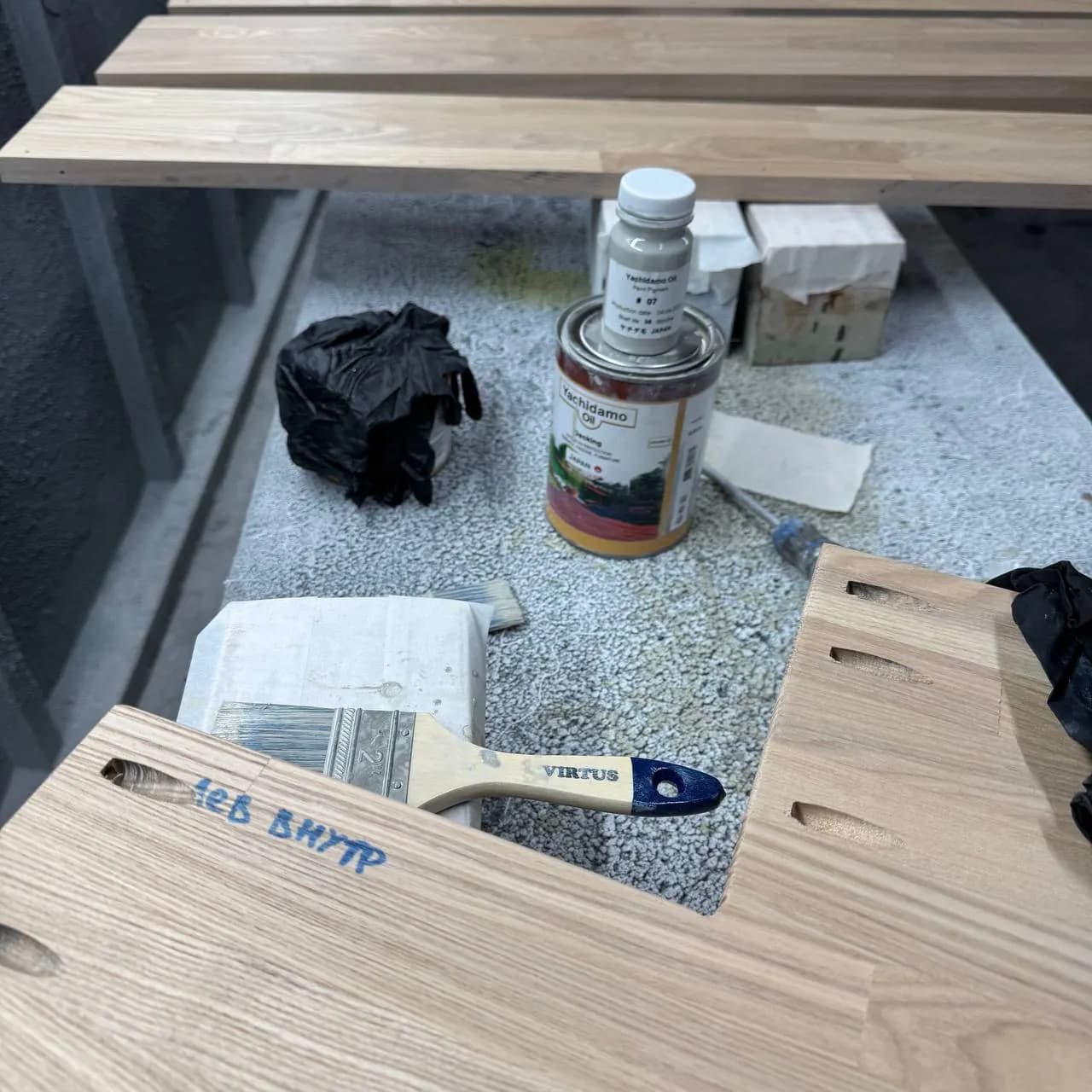 Детали полка из ясеня на козлах, рядом банка Yachidamo Oil Decking, пигмент 07 и кисть