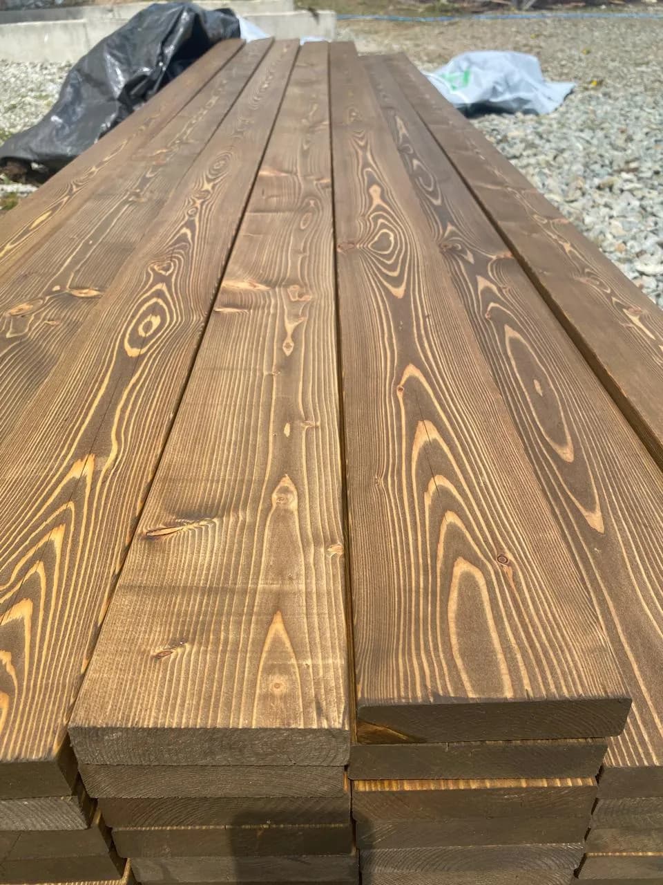 Палубная доска под маслом Decking сложена на площадке объекта, снимок до монтажа