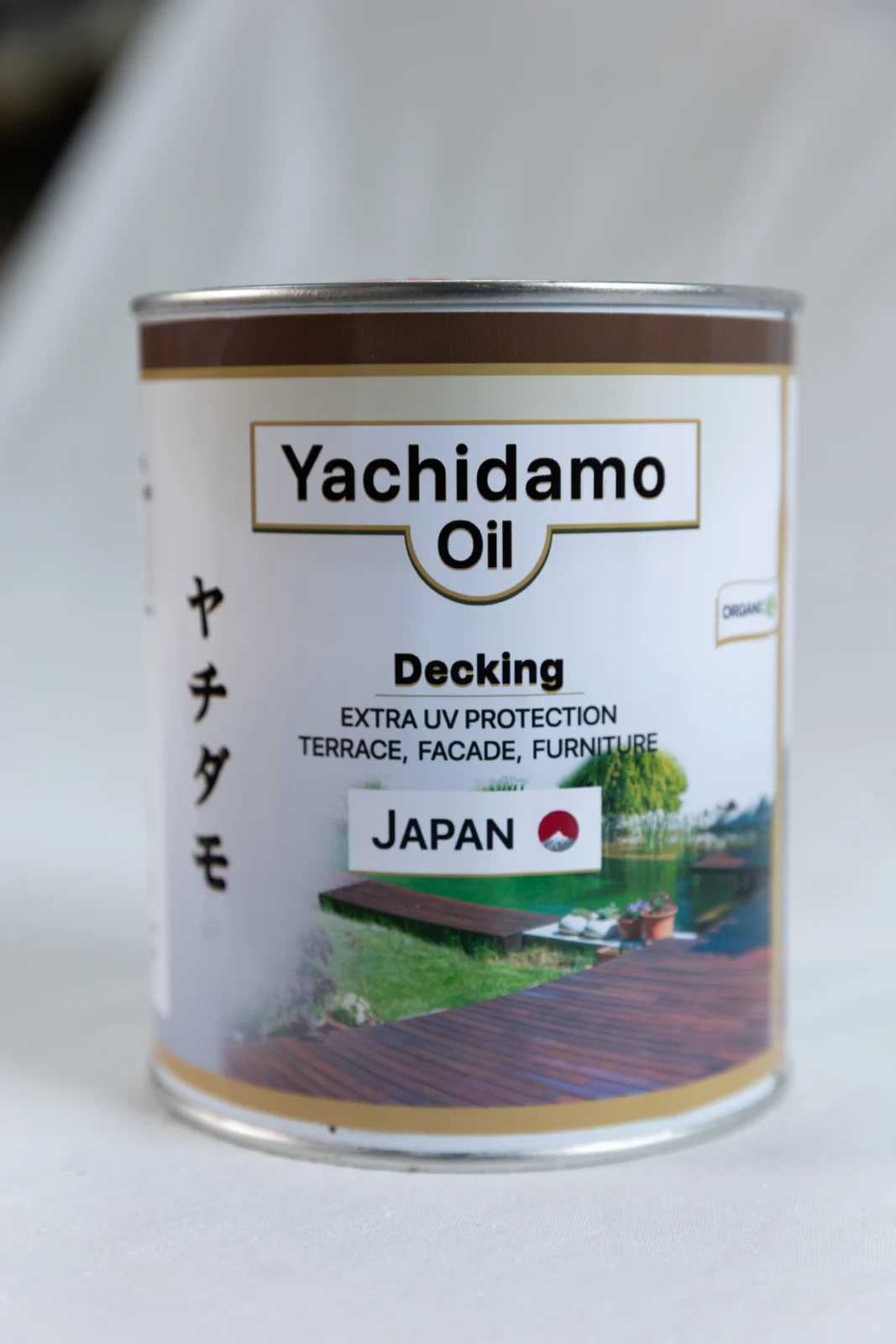 Литровая банка Yachidamo Decking на светлой ткани крупным планом: этим маслом покрыт пол закрытой беседки у бани